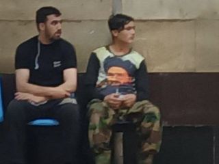 عکس روز: یک پسر افغان با تی شرتی با تصویر یکی از رهبران طالبان در متروی تهران
